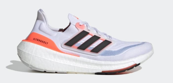 Side view of white, black, and orange adidas running shoe.